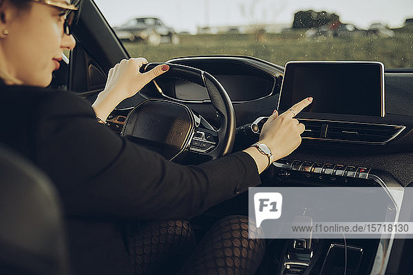Young woman using navigation device in car