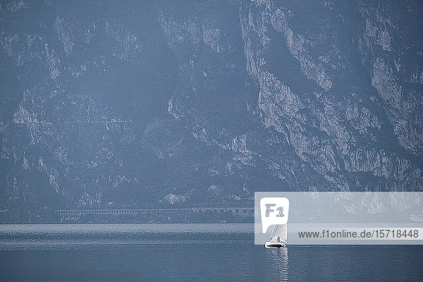 Italy  Trentino  Nago-Torbole  Sailboat sailing near coastal cliffs of Lake Garda