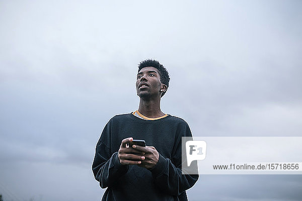 Teenager using his smartphone low angle view