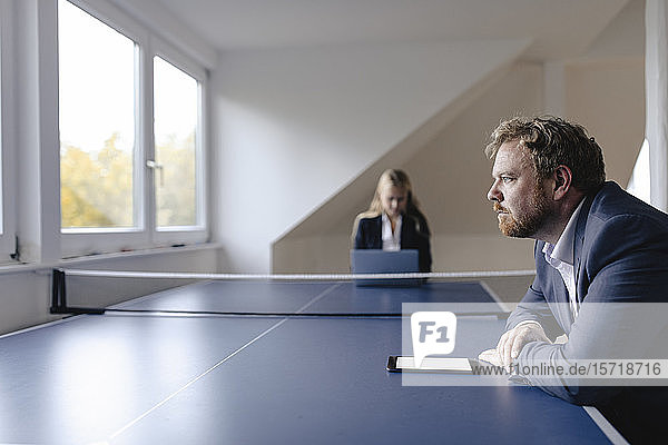 Geschäftsmann und Geschäftsfrau  die am Tischtennistisch im Büro arbeiten