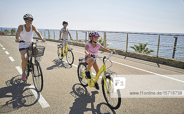 Mother with children during bicycle tour between San Lorenzo and San Remo  Italy