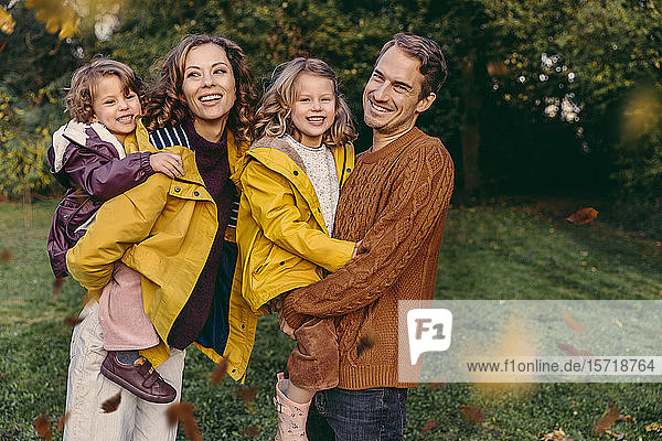 Portrait of happy family with two daughters outdoors in autumn
