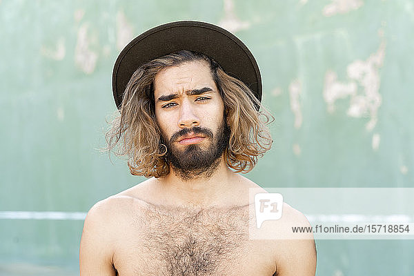 Porträt eines jungen Mannes ohne Hemd mit Hut