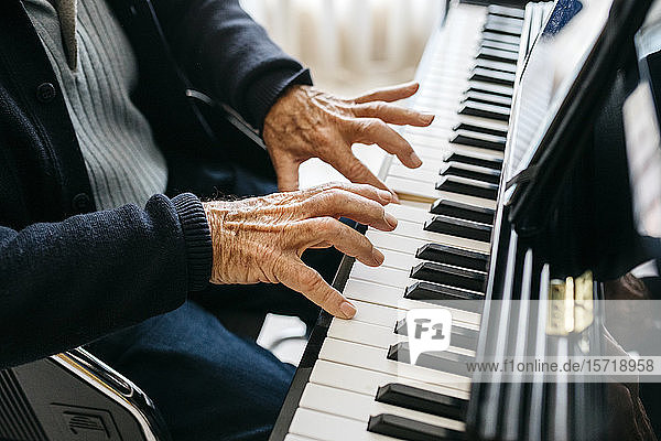 Crop view of senior man playing piano