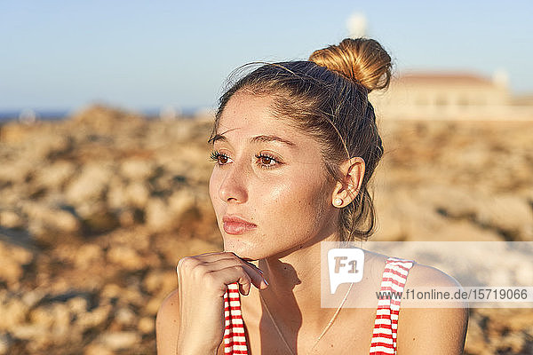 Porträt einer jungen Frau an einem felsigen Strand