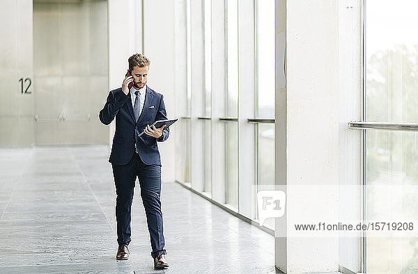 Businessman holding tablet talking on the phone