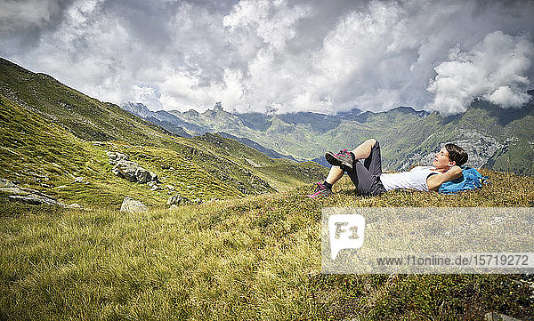 Woman having a break from hiking lying on alpine meadow  Passeier Valley  South Tyrol  Italy