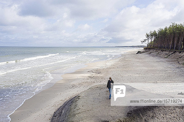 Russia Kaliningrad Oblast Zelenogradsk Man walking along sandy coastal beach of Baltic Sea