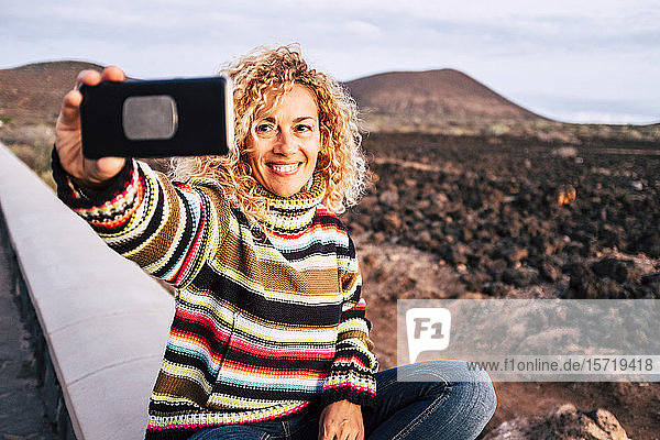 Porträt einer Frau  die einen bunten Pullover trägt und sich ein Selfie nimmt  Teneriffa  Spanien