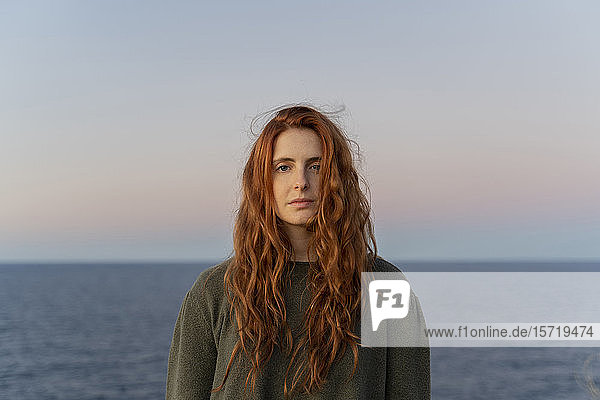 Portrait of redheaded young woman at the coast at sunset  Ibiza  Spain