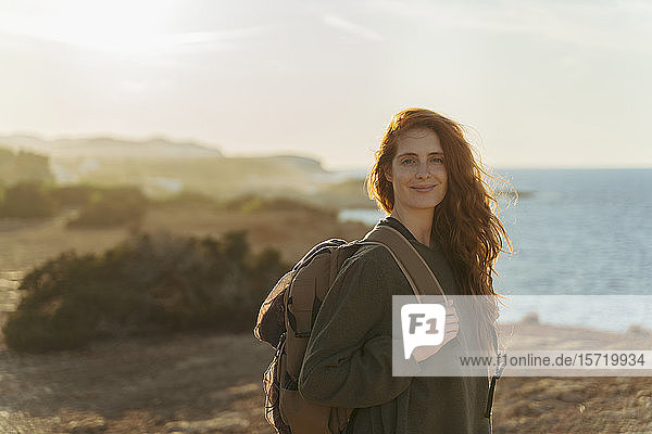 Porträt einer rothaarigen jungen Frau an der Küste bei Sonnenuntergang  Ibiza  Spanien