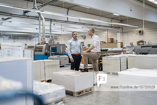 Two colleagues talking in a factory