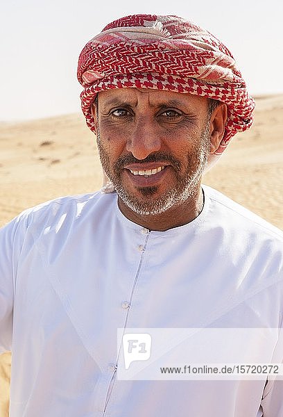 Portrait  Bedouin in traditional headgear  sandy desert Rimal Wahiba Sands  Oman  Asia
