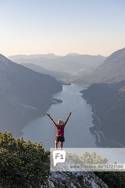 Young woman stretches arms in the air  view from the mountain Bärenkopf to Lake Achensee  Tyrol  Austria  Europe