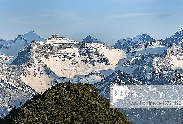 Gipfelkreuz am Martinskopf  Blick vom Herzogstand  Karwendelgebirge im Hintergrund  schneebedeckte Berge  Bayern  Deutschland  Europa