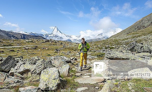 Hiker on 5 lakes Hiking trail  snow-covered Matterhorn at the back  Valais  Switzerland  Europe