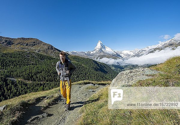 Hiker on the 5 lakes hiking trail  snow-covered Matterhorn at the back  Zermatt  Valais  Switzerland  Europe