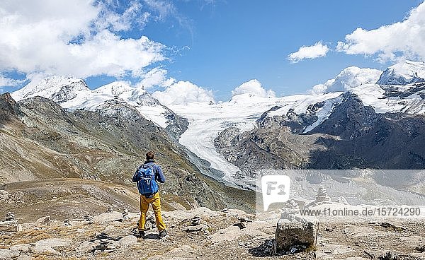 Hiker looks from the mountain Unterrothorn onto the glacier tongue of the Findel Glacier  Zermatt  Walliss  Switzerland  Europe