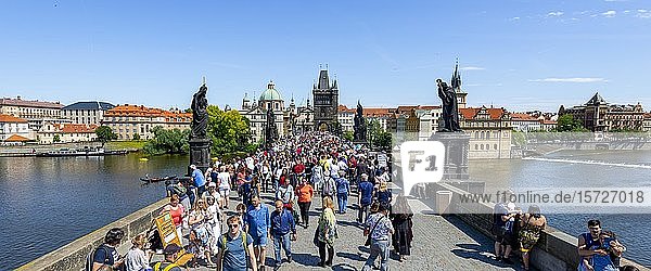 Crowd on Charles Bridge  Karl?v most  behind Church of the Holy Cross with Old Town Bridge Tower  Prague  Bohemia  Czech Republic  Europe