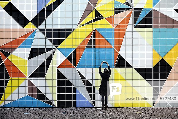 A woman photographs the mural Hornet  artist Sarah Morris  Paul Klee-Platz at the art collection  Düsseldorf  North Rhine-Westphalia  Germany  Europe