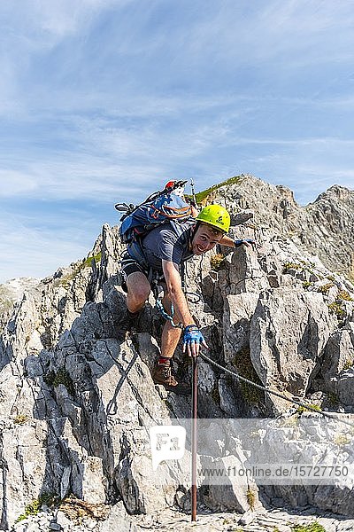 Bergsteiger  junger Mann klettert über Felsen  Bergsteiger auf einem gesicherten Klettersteig  Mittenwalder Klettersteig  Karwendelgebirge  Mittenwald  Deutschland  Europa