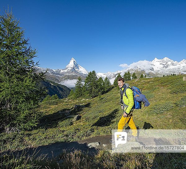 Hiker on the 5 lakes hiking trail  snow-covered Matterhorn at the back  Zermatt  Valais  Switzerland  Europe