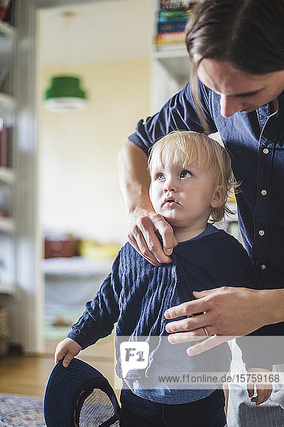 Mann bereitet blonden Kleinkind-Sohn zu Hause vor