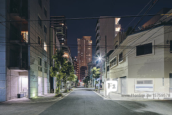 Nächtliche Szene mit Apartmenthäusern in der Innenstadt  Einzelhandelsgebäuden und modernen Bürogebäuden in der Ferne  Osaka  Japan