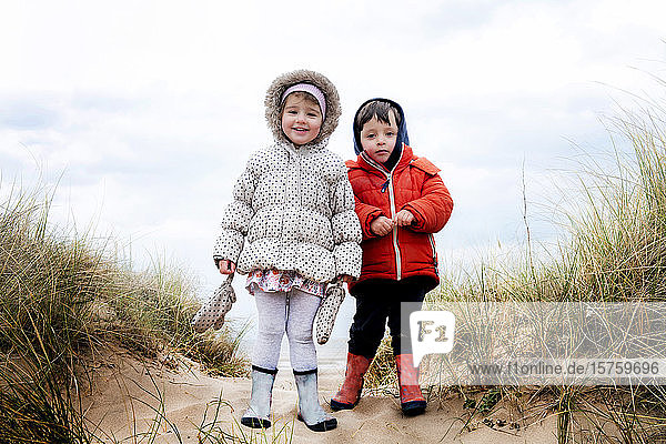 Siblings exploring beach