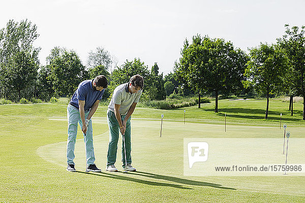 Friends playing golf on golf course