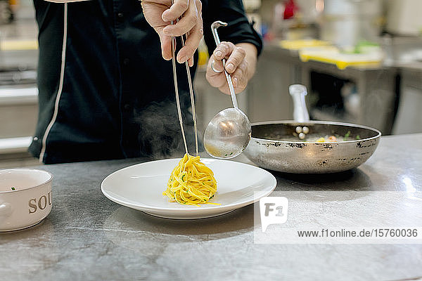 Chef preparing pasta in kitchen