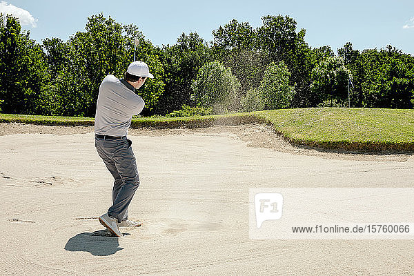 Mann spielt Golf auf dem Golfplatz