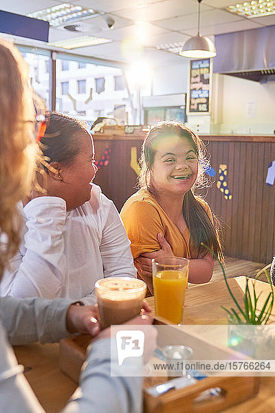 Glückliche junge Frauen mit Down-Syndrom im Café
