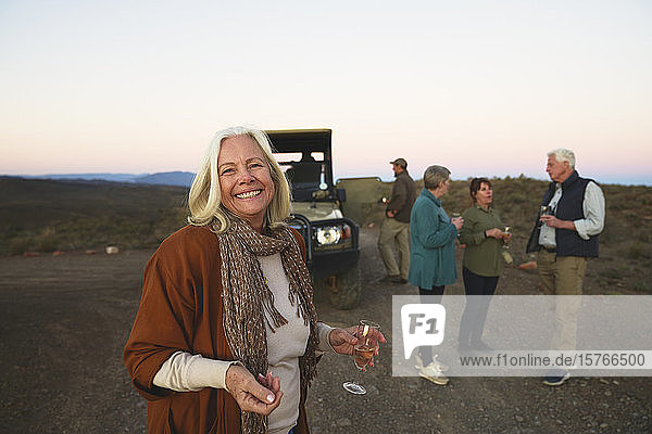 Porträt glückliche ältere Frau trinkt Champagner auf Safari