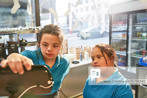 Junge Frauen mit Down-Syndrom arbeiten in einem Cafe