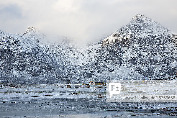 Schneebedeckte Berge und abgelegene Hütten Flakstad Lofoten Norwegen