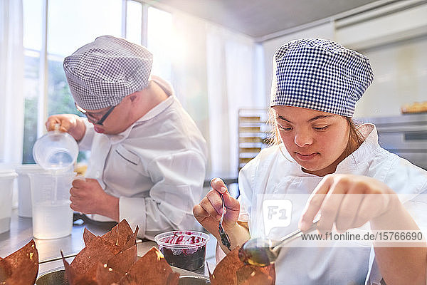 Junge Frau mit Down-Syndrom backt Muffins in der Küche