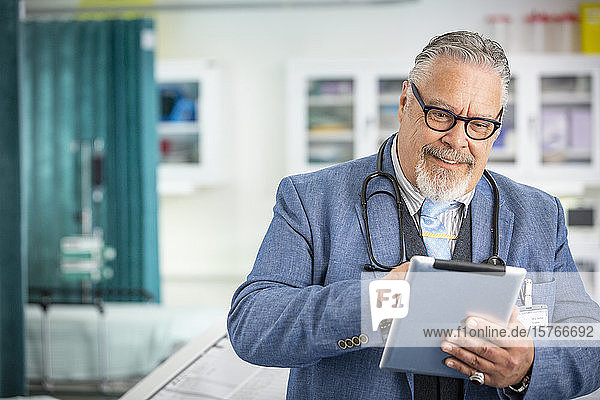 Männlicher Arzt mit digitalem Tablet in der Klinik
