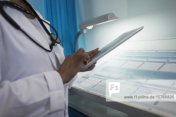 Nahaufnahme einer Ärztin  die ein digitales Tablet in einem Krankenhauszimmer benutzt