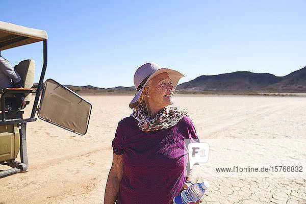 Glückliche ältere Frau auf Safari in der sonnigen trockenen Wüste Südafrikas