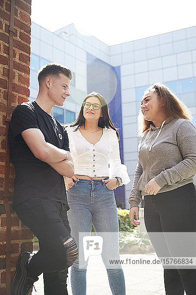 College-Studenten im Gespräch vor einem sonnigen Gebäude