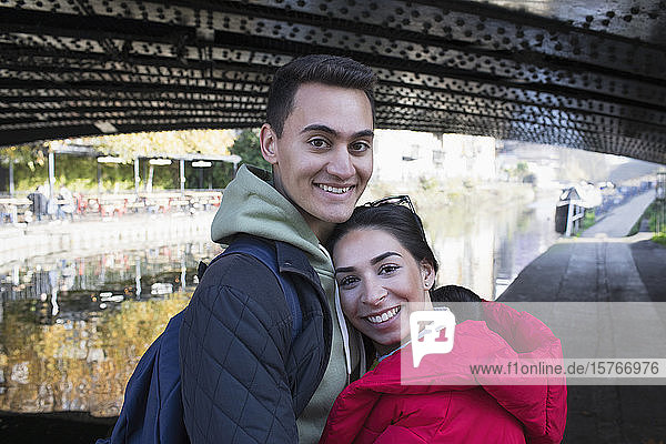 Porträt glückliches junges Paar  das sich entlang des Kanals umarmt