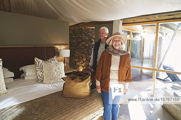 Porträt eines glücklichen älteren Paares bei der Ankunft im Hotelzimmer einer Safari-Lodge