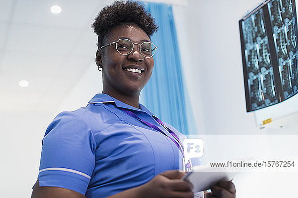 Porträt einer selbstbewussten Krankenschwester mit digitalem Tablet  die Röntgenbilder in einem Krankenhauszimmer prüft