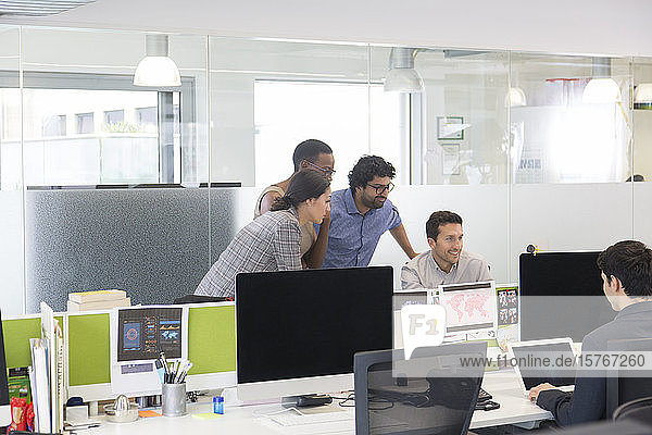 Geschäftsleute treffen sich am Computer in einem Großraumbüro