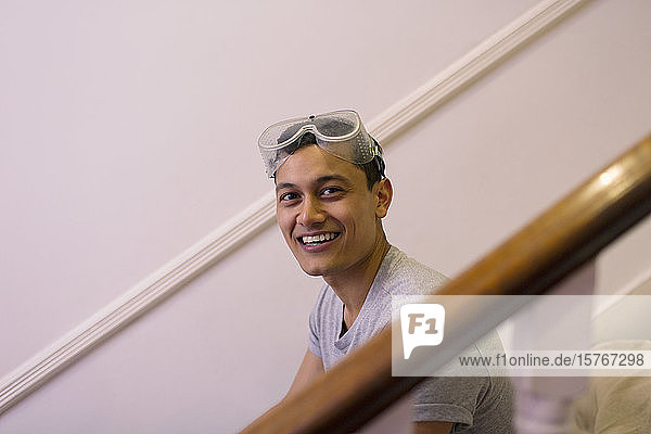 Porträt eines glücklichen  selbstbewussten Mannes mit Brille  der sein Haus renoviert