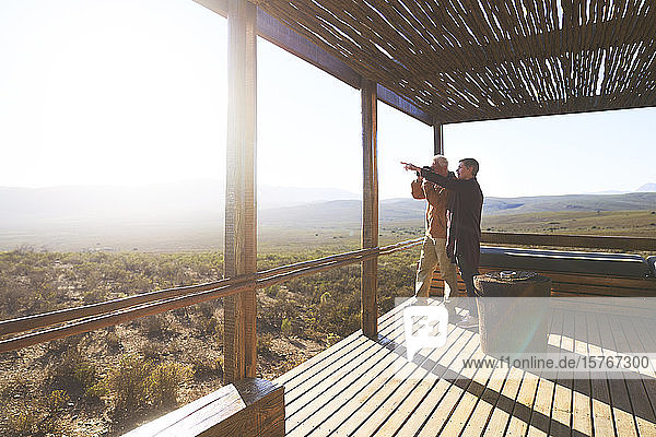 Älteres Paar mit Blick auf die sonnige Aussicht vom Balkon einer Safari-Lodge