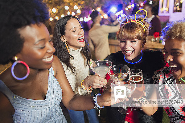 Glückliche Freundinnen stoßen auf einer Party mit Cocktails an
