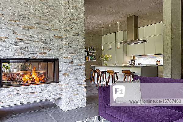 Modernes Wohnzimmer mit gemauertem Kamin  offen zur Küche