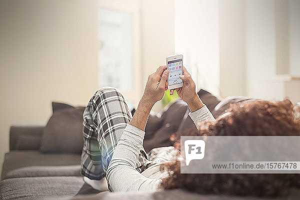 Man relaxing  using smart phone on sofa